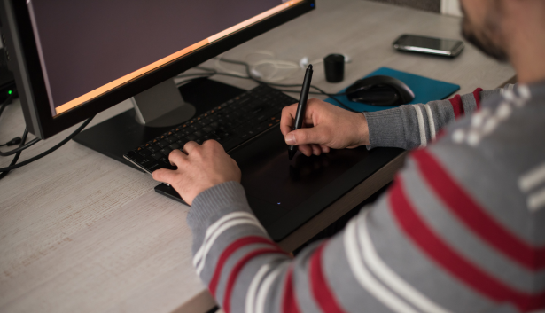 Hombre diseñado en una tableta gráfica en Agencia de SEO en Burgos