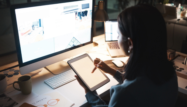 Mujer trabajando en una Tablet en frente de su monitor en Agencia de SEO en Elche
