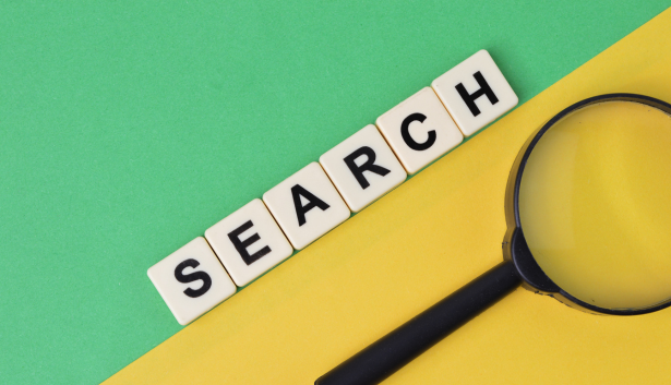 Una lupa al lado de fichas scrabble en Agencia de SEO en Getafe