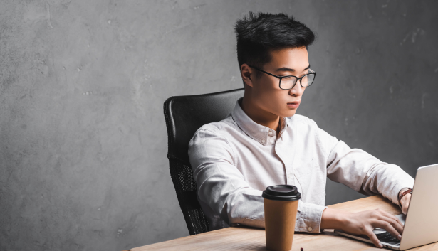 hombre asiáticos escribiendo en una macbook en Agencia de SEO en Mataró