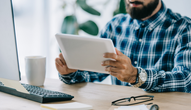 hombre de camisa de cuadros mirando tablet en Agencia de SEO en Móstoles
