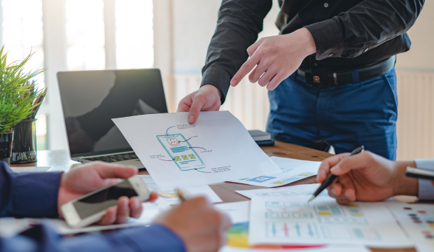 Equipo de especialistas en marketing digital revisando un esquema de aplicación móvil, colaborando en la estrategia de optimización web en una agencia de SEO en Valladolid.
